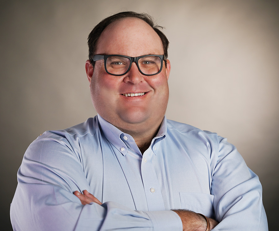 Smiling man in glasses with arms crossed