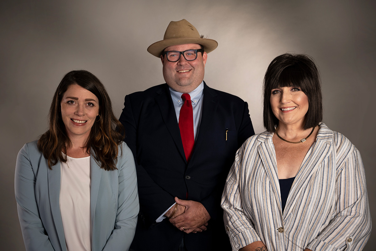 Three professionals posing for a group portrait