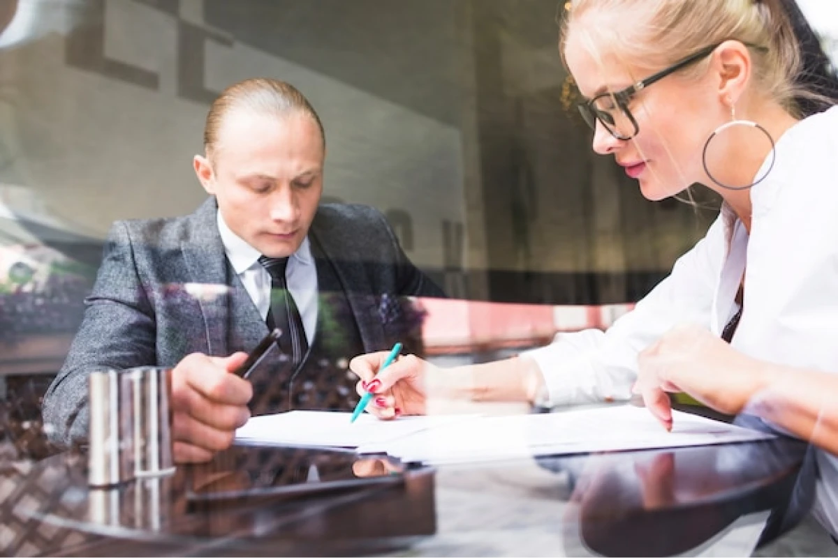 Professionals signing business documents.